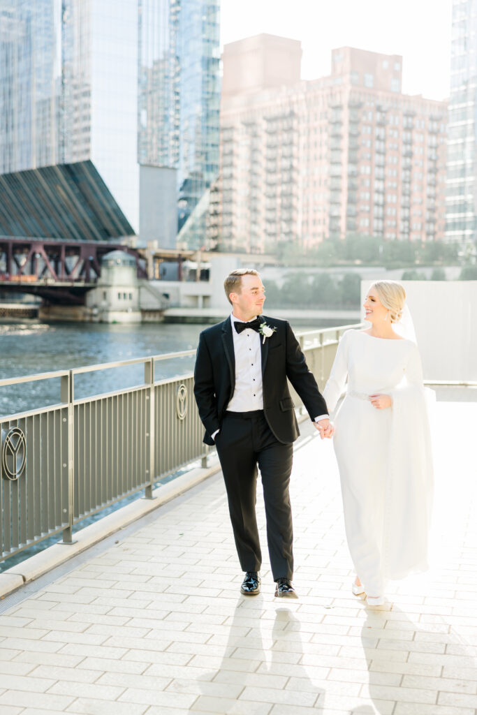 Bride and groom walking holding hands, smiling on their wedding day in Chicago