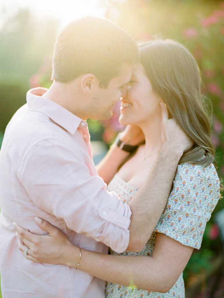 Close up of a couple is kissing in a rose garden at sunset